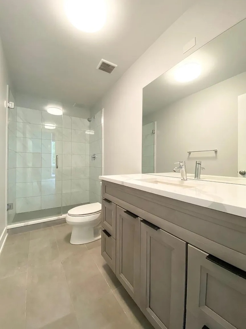 Undisclosed Address Chicago, IL 60640 - Photo 10 of 16 a bathroom with a double vanity sink toilet and shower