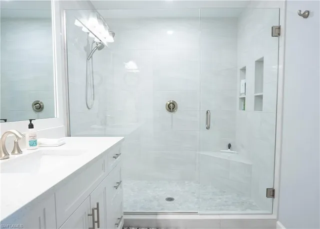 a bathroom with a shower sink and mirror