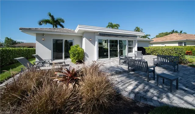 a view of a house with backyard and sitting area