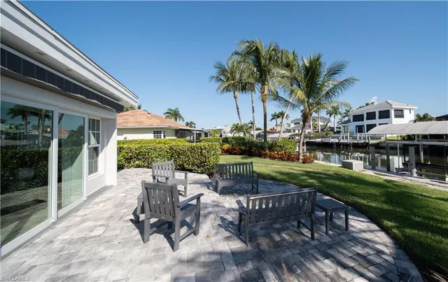 a view of backyard with outdoor seating and plants