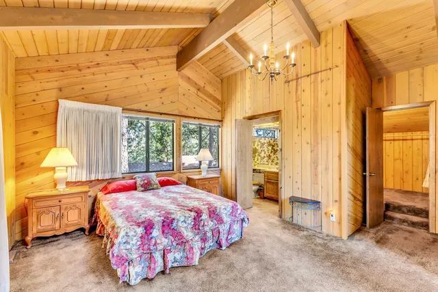 a bedroom with a bed and large windows