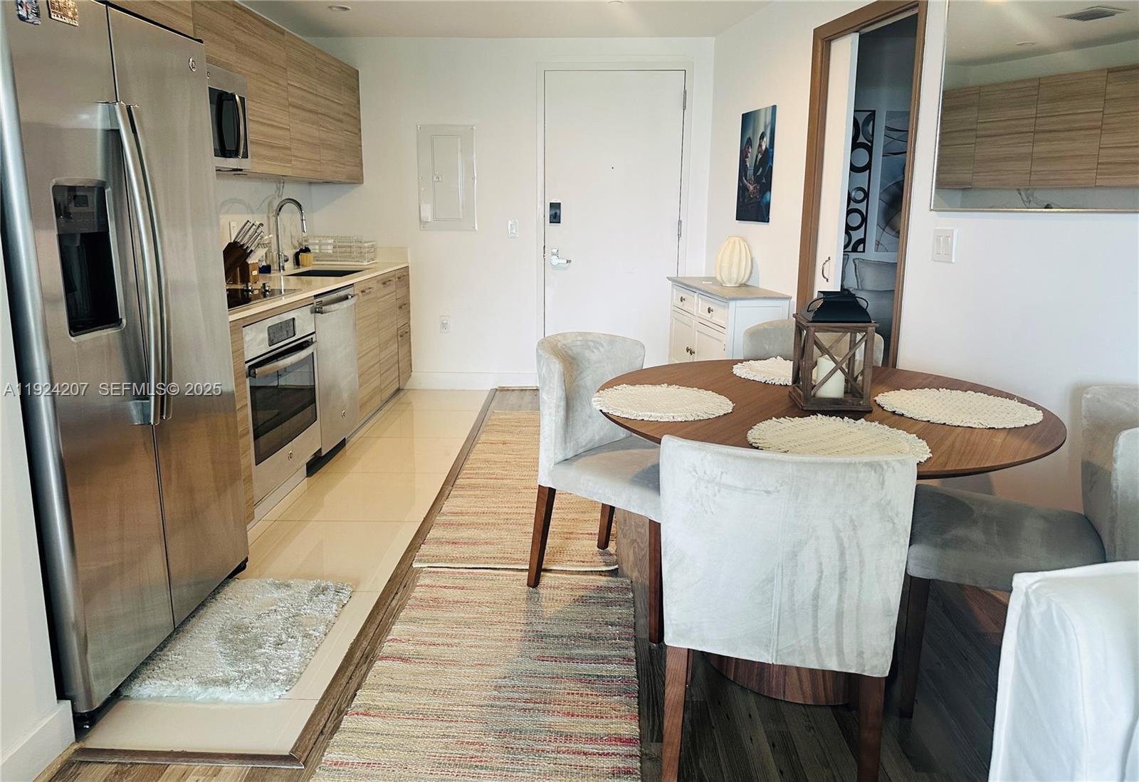 121 Northeast 34th Street, Unit 3014 Miami, FL 33137 - Photo 13 of 54 a kitchen with stainless steel appliances wooden floor dining table and chairs