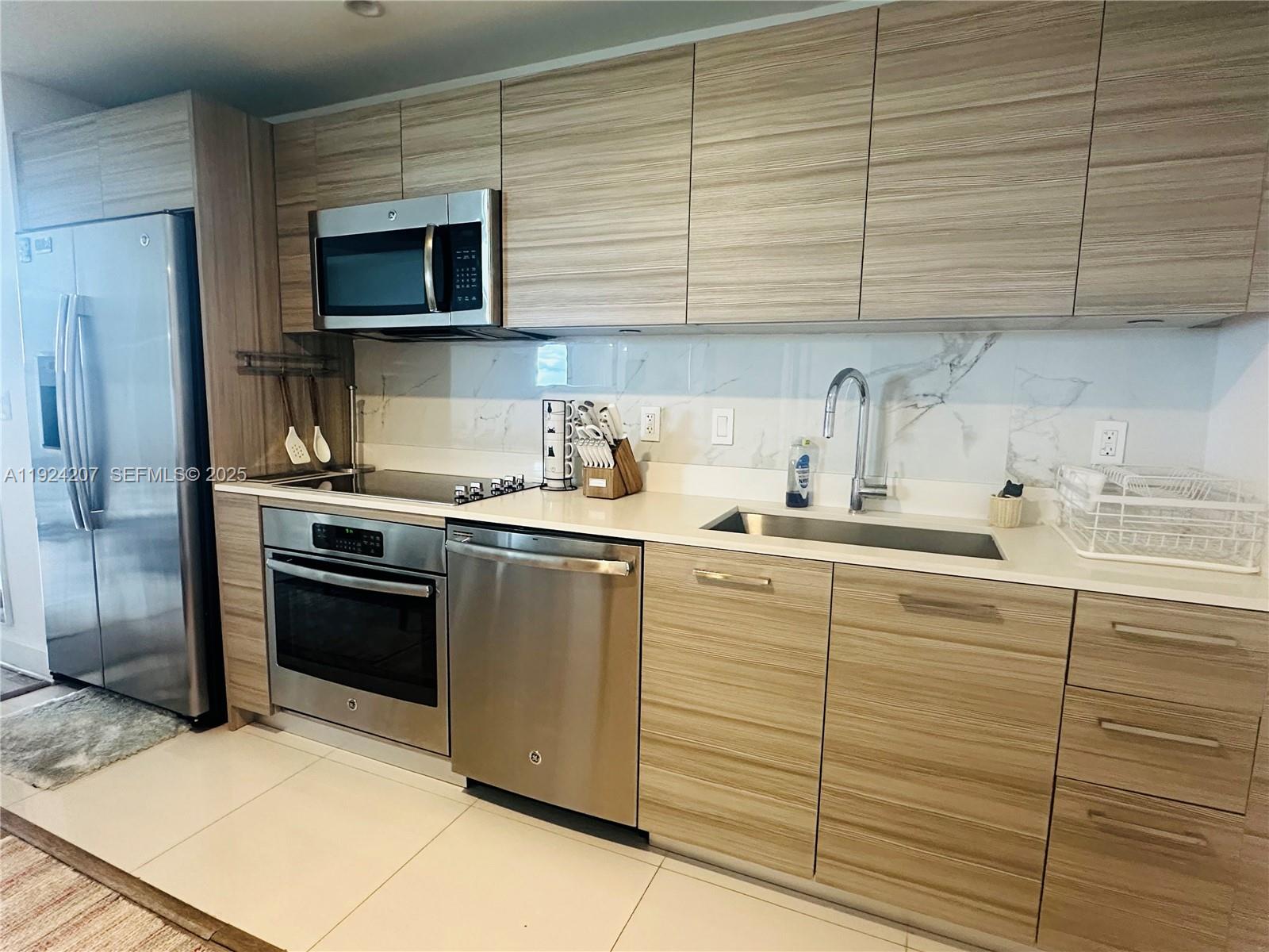 121 Northeast 34th Street, Unit 3014 Miami, FL 33137 - Photo 15 of 54 a kitchen with a sink cabinets and stainless steel appliances