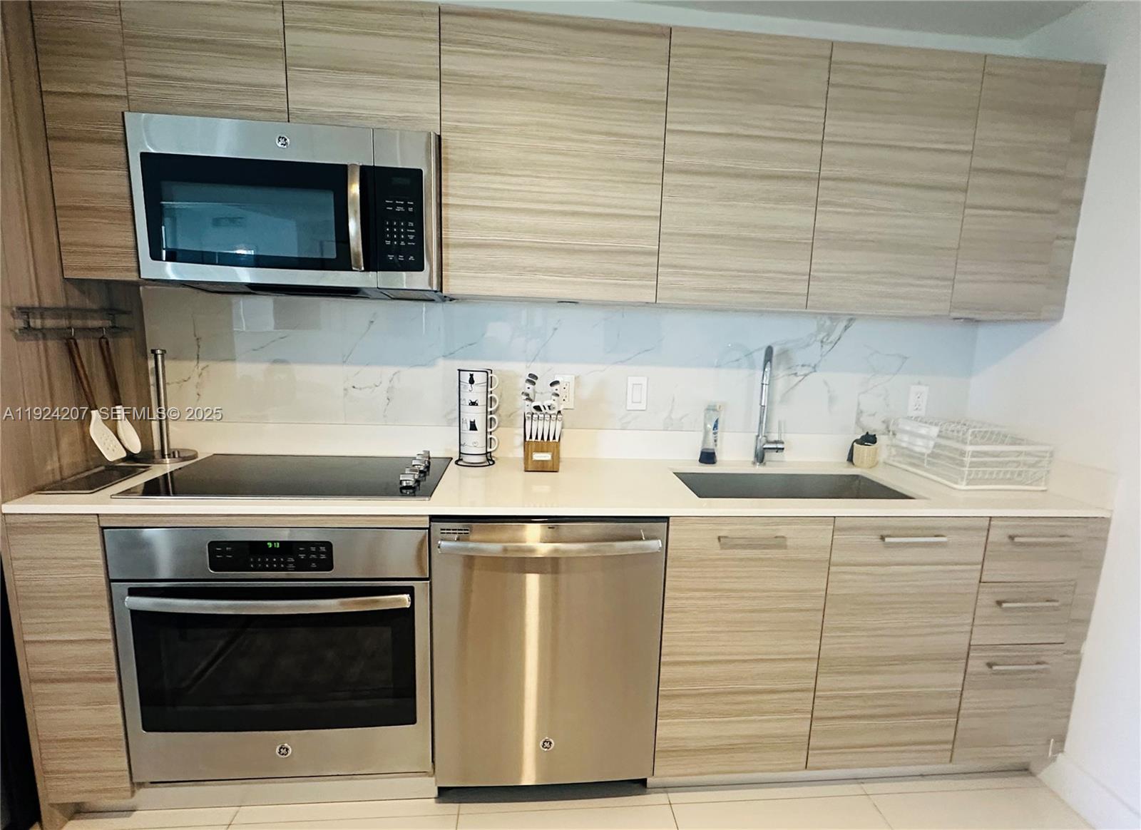 121 Northeast 34th Street, Unit 3014 Miami, FL 33137 - Photo 17 of 54 a kitchen with stainless steel appliances granite countertop a stove and a microwave