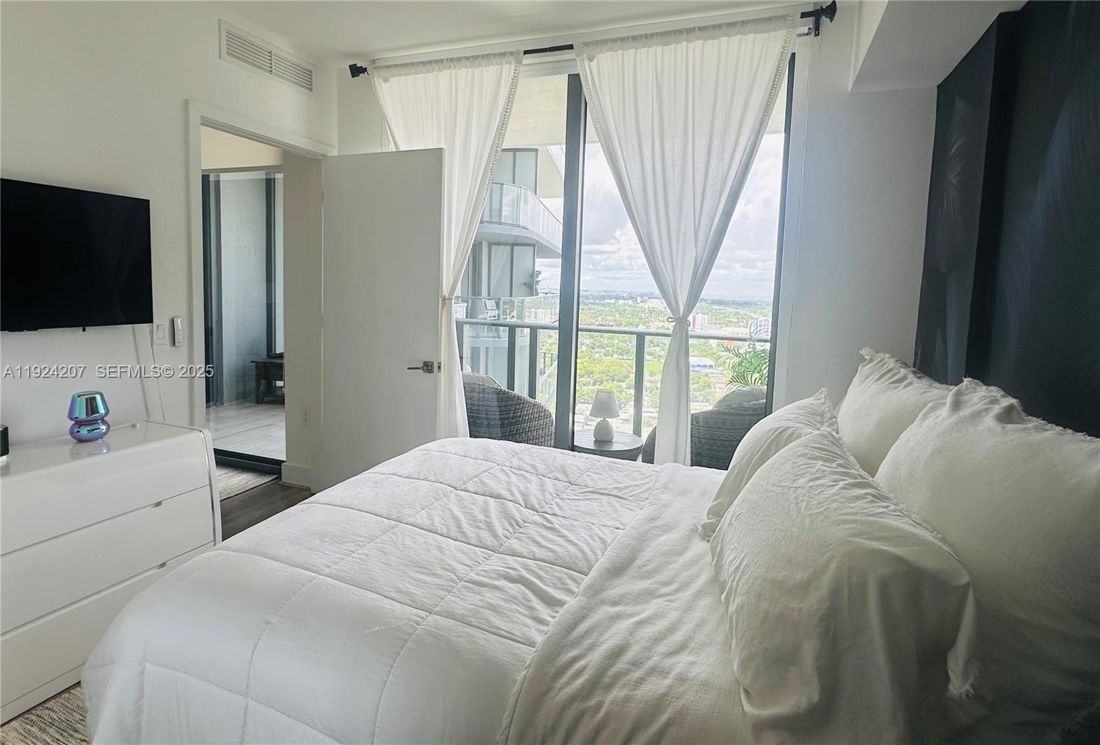 121 Northeast 34th Street, Unit 3014 Miami, FL 33137 - Photo 27 of 54 a bedroom with a bed and a flat screen tv