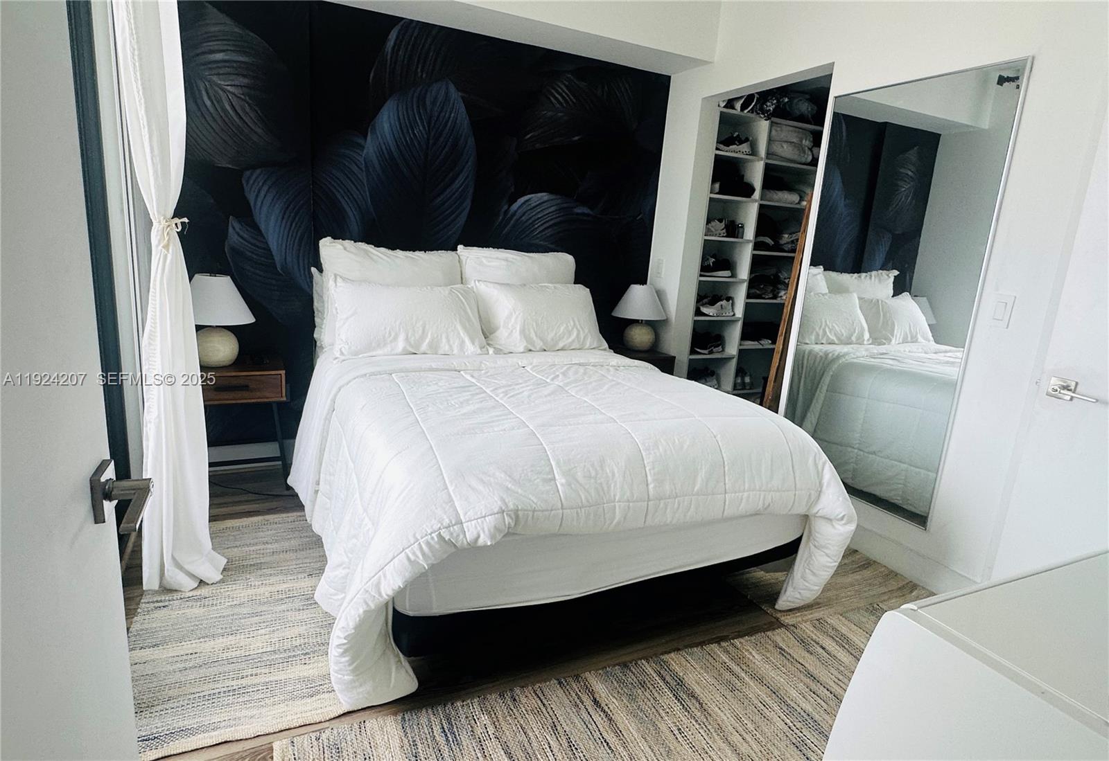 121 Northeast 34th Street, Unit 3014 Miami, FL 33137 - Photo 29 of 54 a bed sitting in a bedroom next to a wooden cabinet