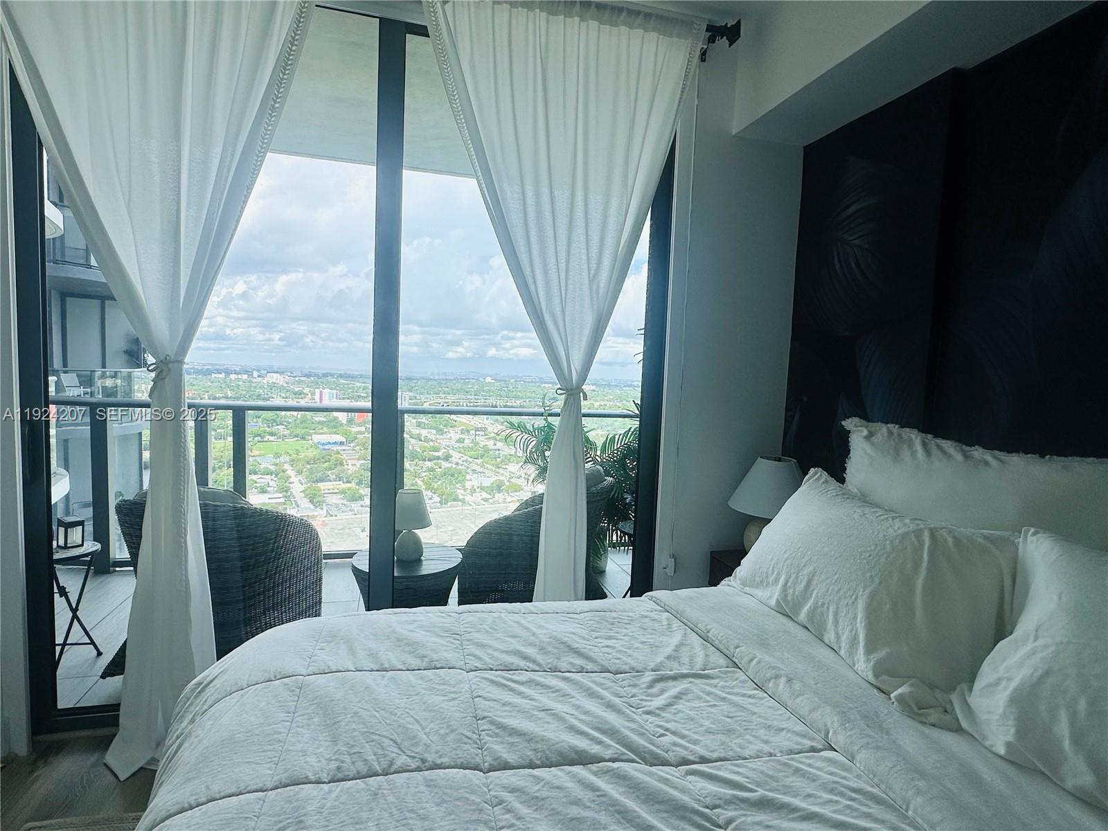 121 Northeast 34th Street, Unit 3014 Miami, FL 33137 - Photo 30 of 54 a bedroom with a bed and a large window