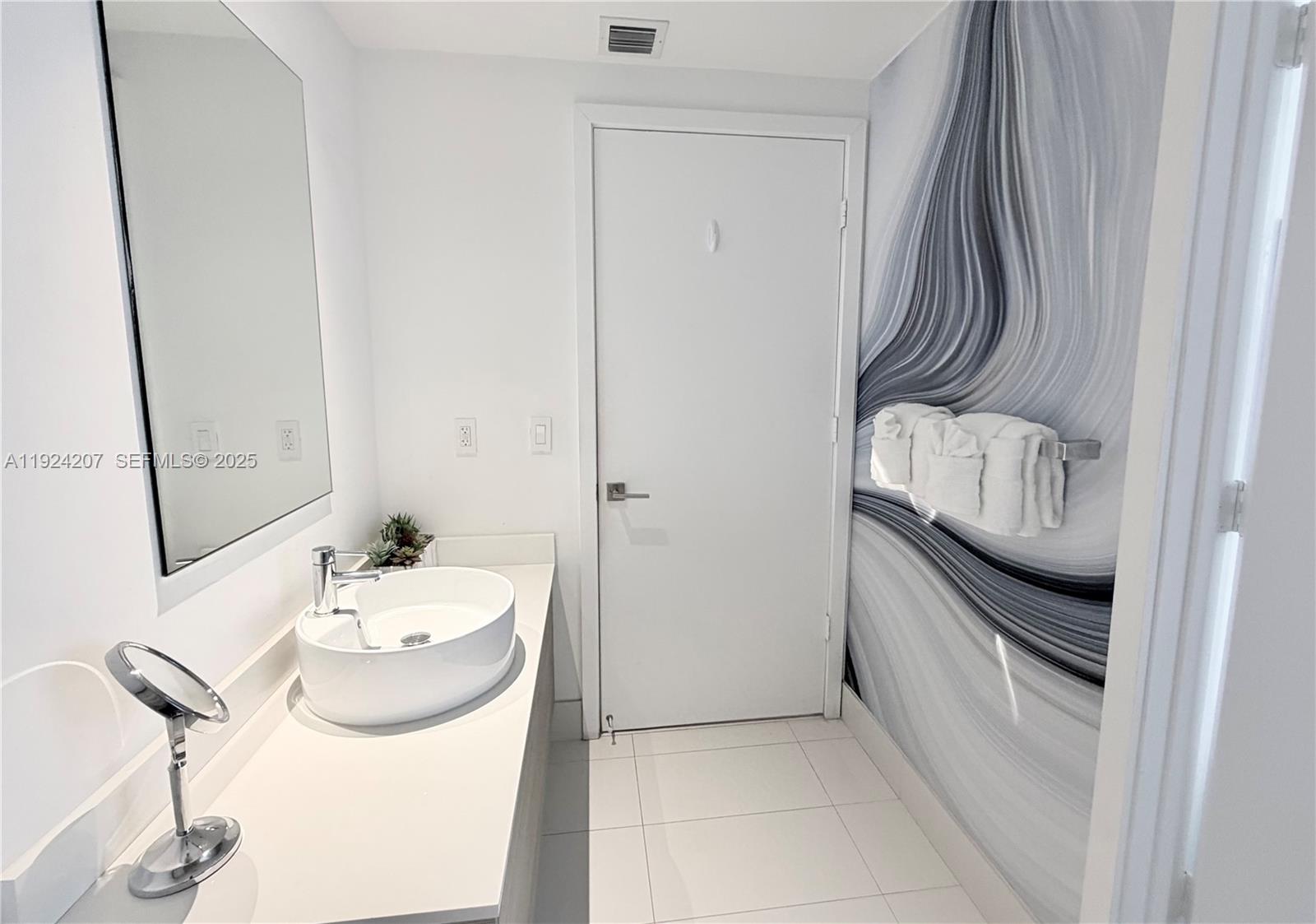 121 Northeast 34th Street, Unit 3014 Miami, FL 33137 - Photo 35 of 54 a bathroom with a sink and a mirror