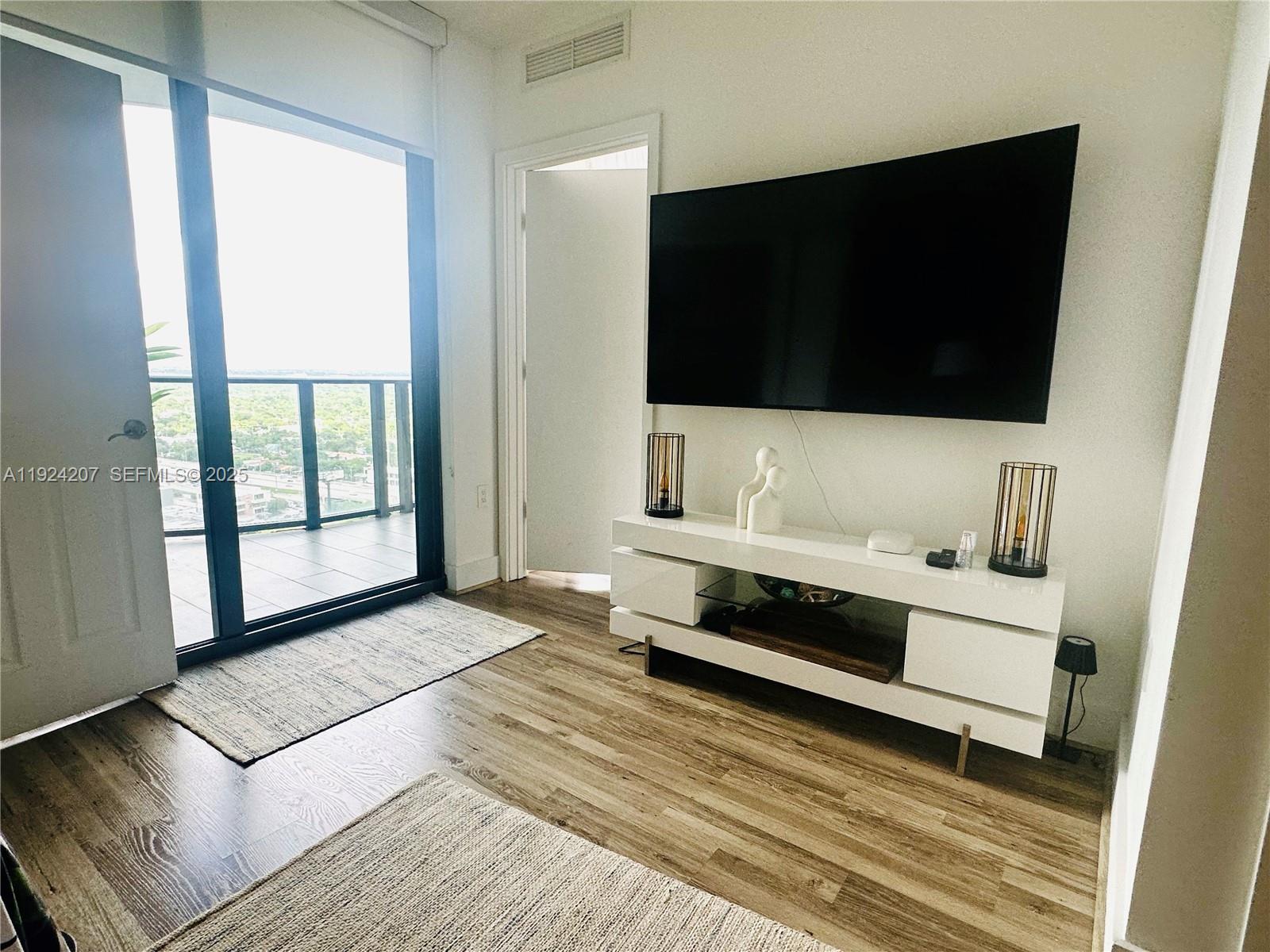 121 Northeast 34th Street, Unit 3014 Miami, FL 33137 - Photo 9 of 54 a living room with a flat screen tv and a rug