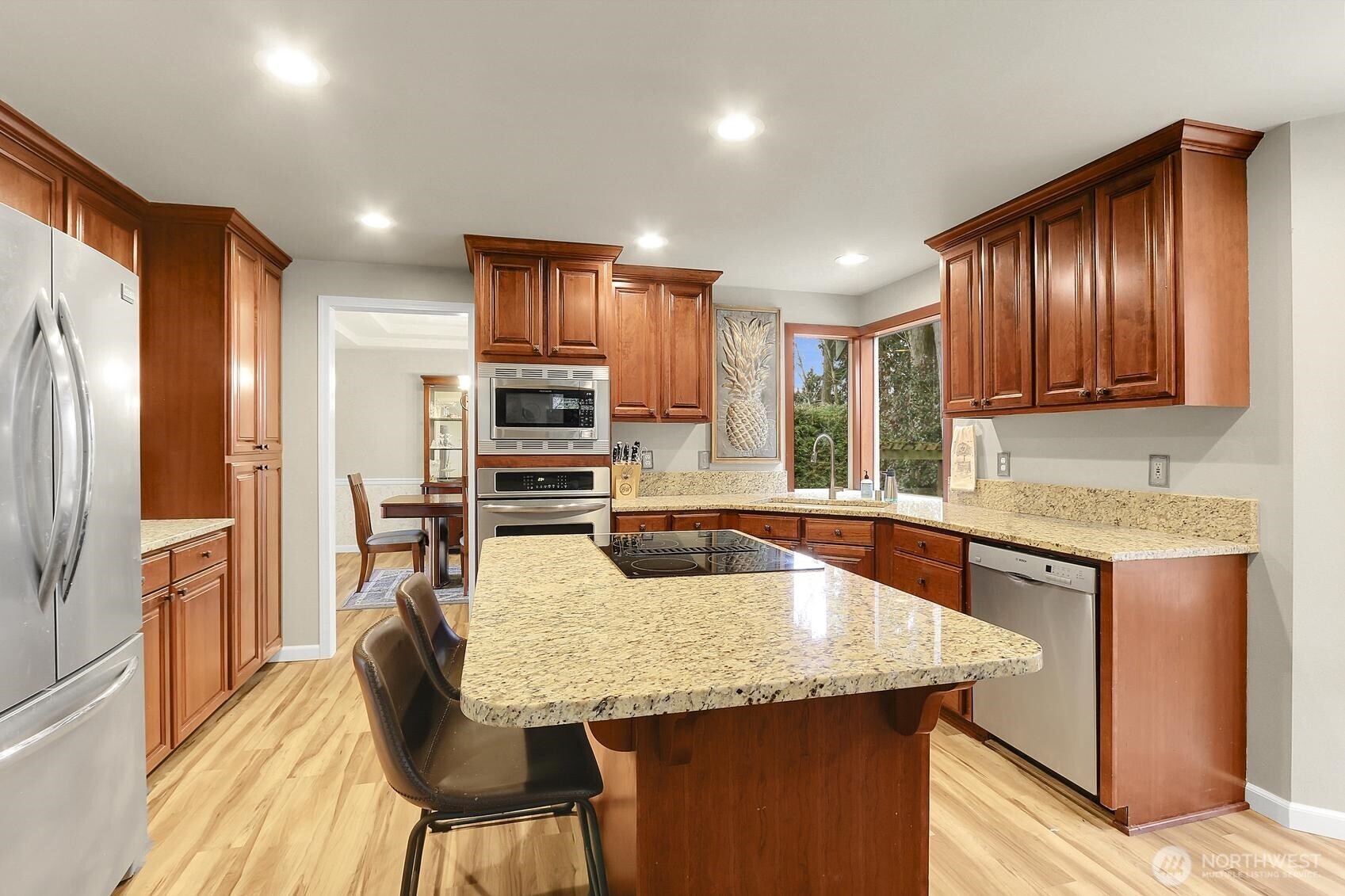 2107 237th Place Southeast Bothell, WA 98021 - Photo 12 of 40 a kitchen with granite countertop kitchen island wooden cabinets a refrigerator a stove a sink and island