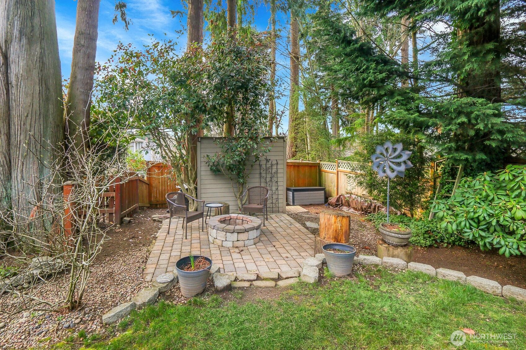 2107 237th Place Southeast Bothell, WA 98021 - Photo 33 of 40 a view of a backyard with table and chairs potted plants and large tree