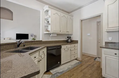 a kitchen with granite countertop a sink stove and cabinets