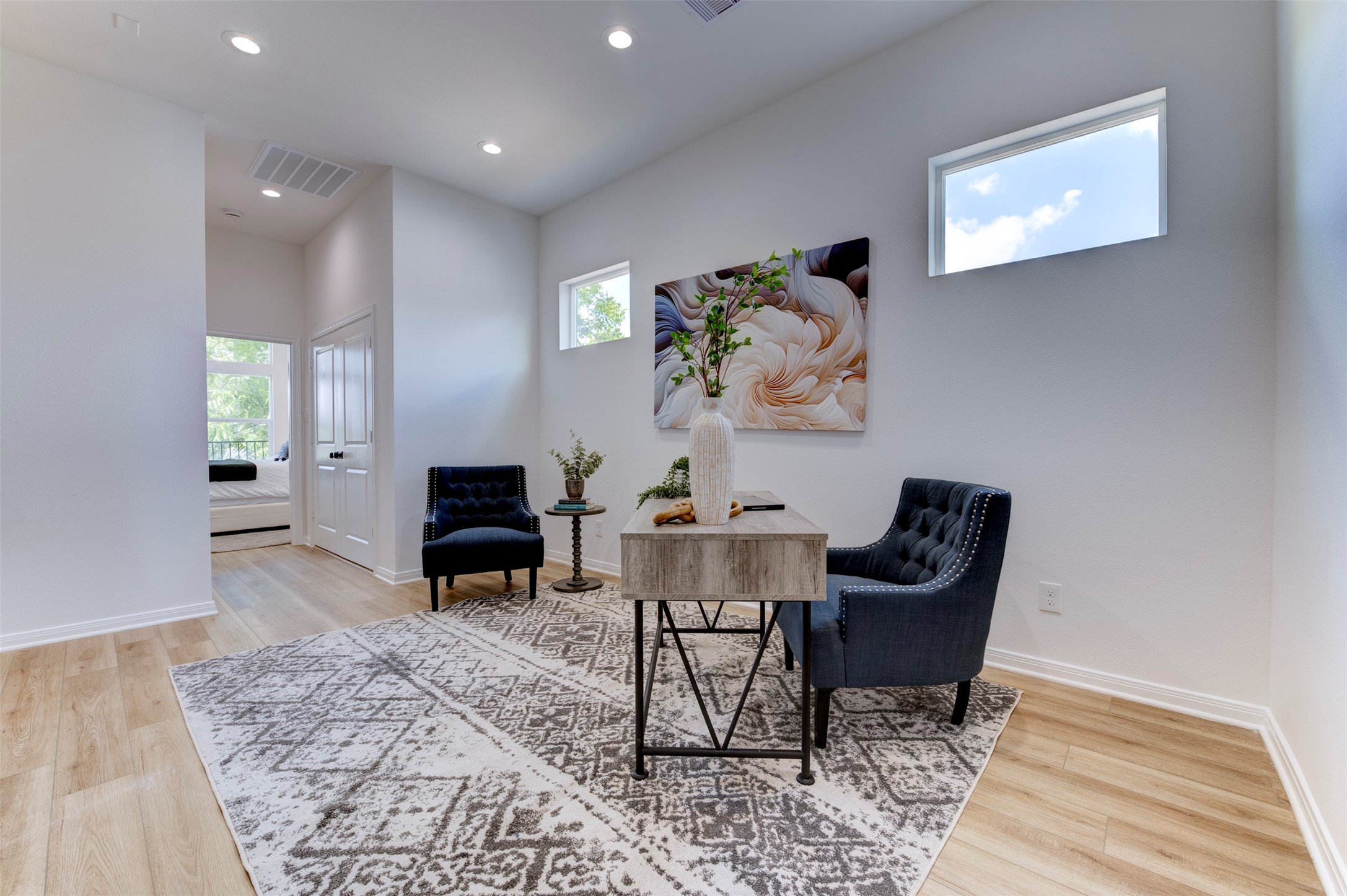 6807 Paris Street Houston, TX 77021 - Photo 33 of 50 Open flex room with hardwood floors, high ceilings, recessed lighting, dual clerestory windows, and direct sightline to secondary bedroom hallway. Double doors visible at rear.