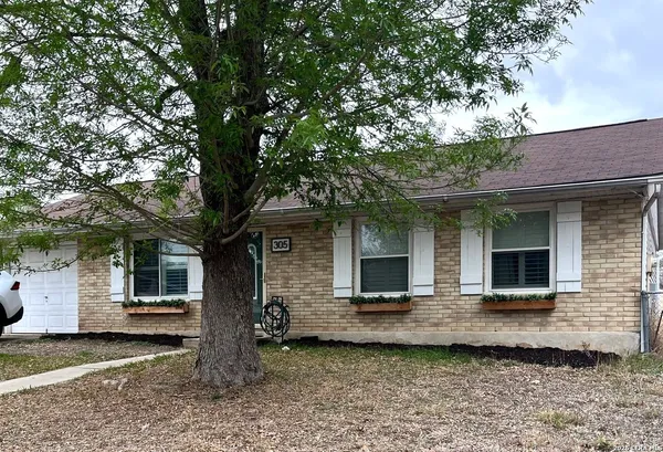 a front view of a house with glass windows and yard