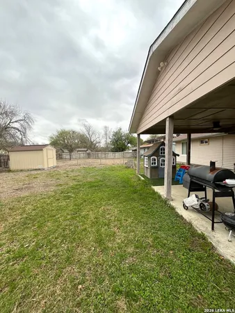 a view of a backyard with table and chairs and wooden fence