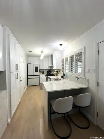 a kitchen with counter and chairs