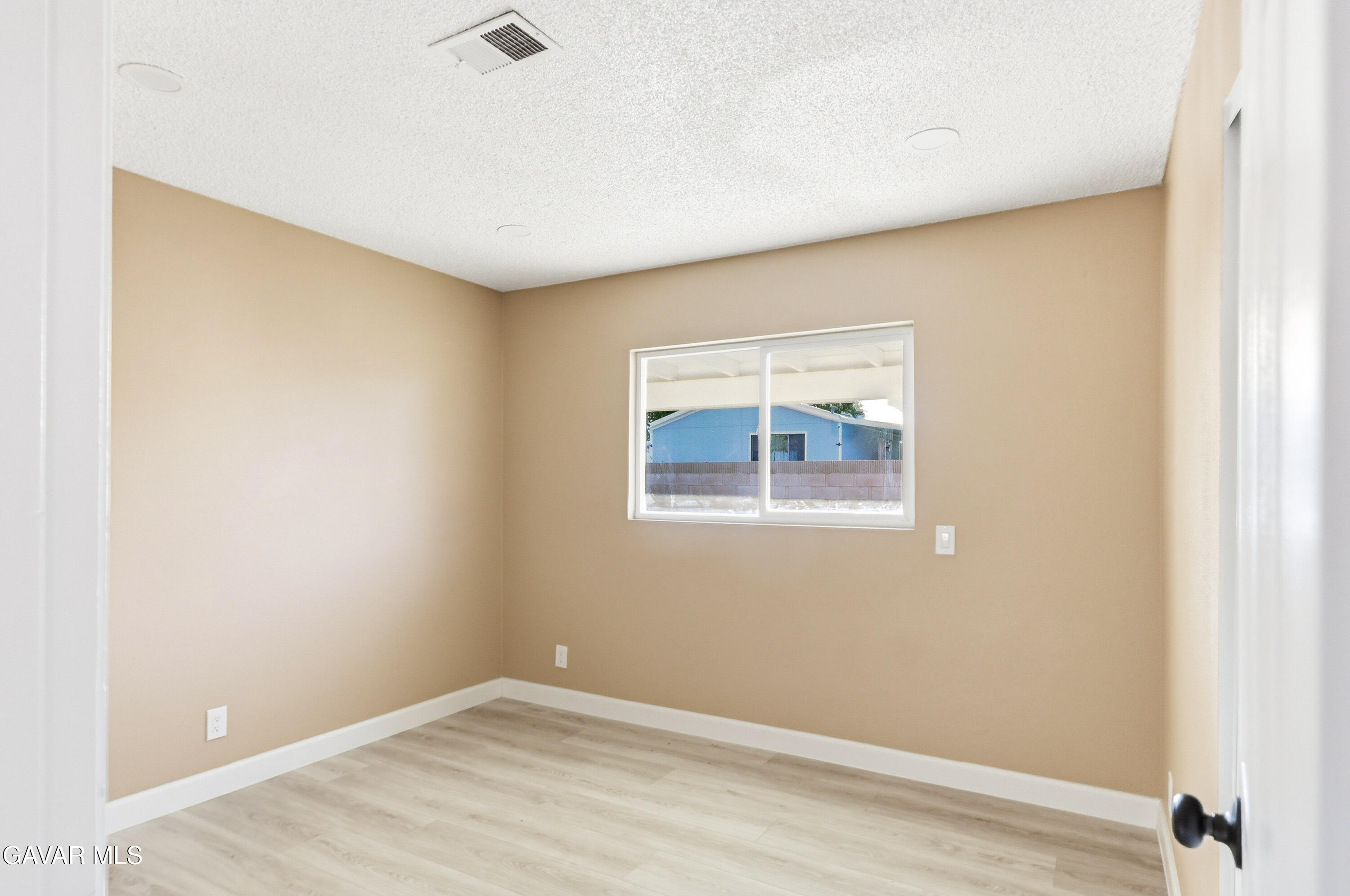 3340 West Roxbury Street Rosamond, CA 93560 - Photo 16 of 20 a view of an empty room with wooden floor and a window