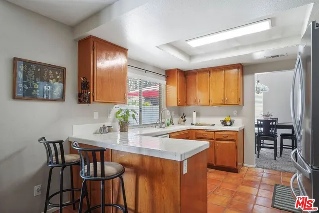 a kitchen with a sink and chairs