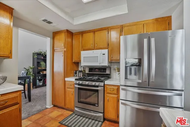 a kitchen with stainless steel appliances a refrigerator sink and stove