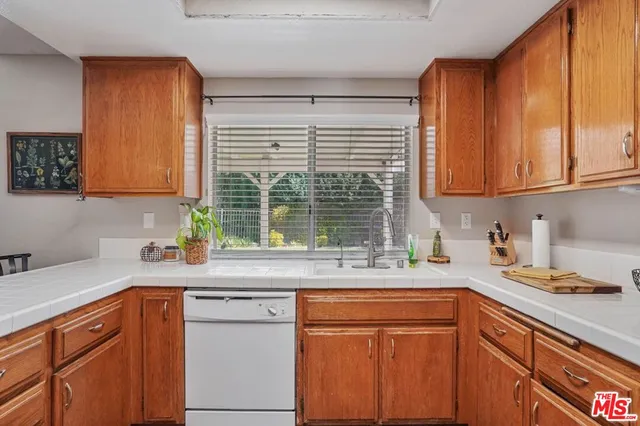 a kitchen with stainless steel appliances granite countertop wooden cabinets a sink and a window