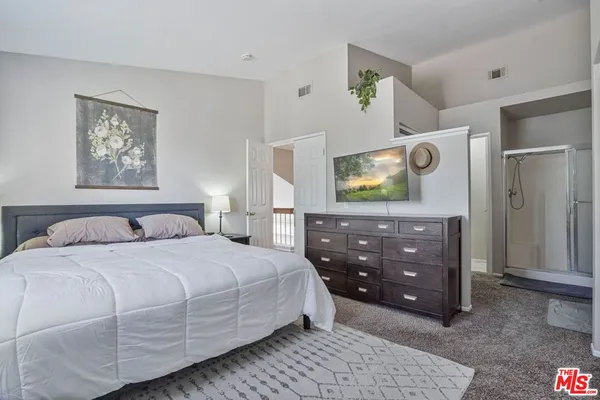 a bedroom with a bed and a flat screen tv