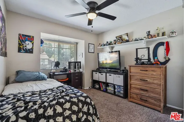 a bedroom with a bed and a flat tv screen on dresser