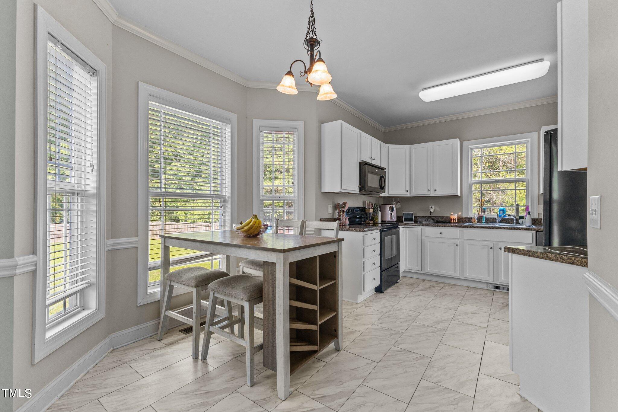 156 Williams Creek Drive Erwin, NC 28339 - Photo 20 of 37 a kitchen with a stove a table and chairs in it