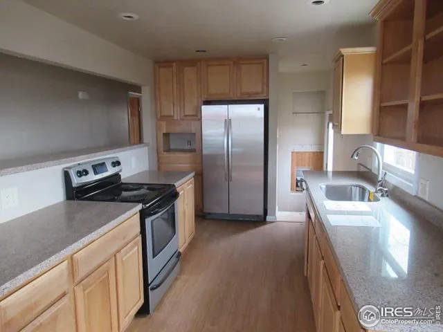 a kitchen with stainless steel appliances granite countertop a sink a stove and a refrigerator