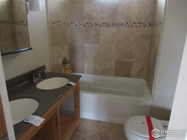 a bathroom with a granite countertop sink a toilet a mirror and shower