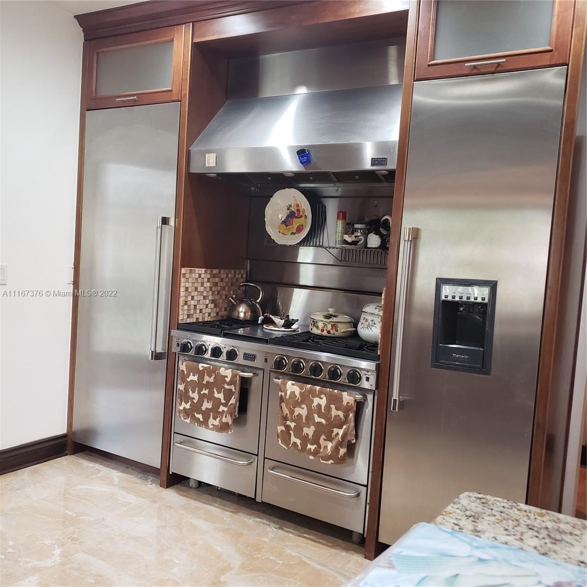 450 Southwest 19th Road Miami, FL 33129 - Photo 6 of 12 a kitchen with stainless steel appliances granite countertop a stove and a refrigerator