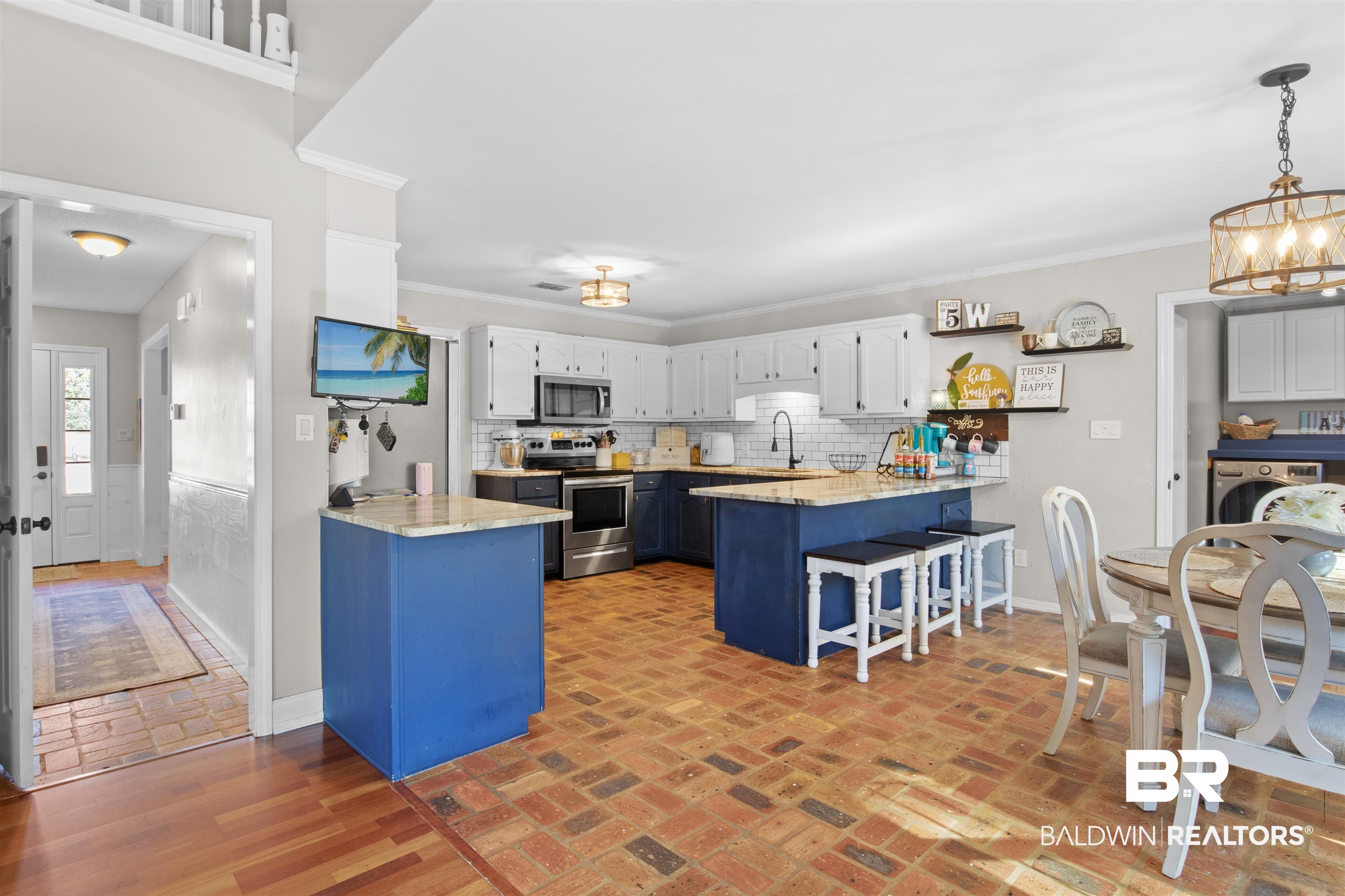 131 Marikesh Drive Daphne, AL 36526 - Photo 20 of 29 Kitchen with blue cabinetry, a breakfast bar, hanging light fixtures, kitchen peninsula, and stainless steel appliances