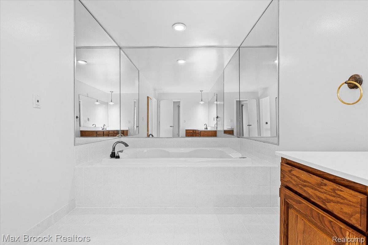 1830 Lone Pine Road Bloomfield Hills, MI 48302 - Photo 37 of 70 Built-in soaking tub with chrome fixtures, surrounded by white tile