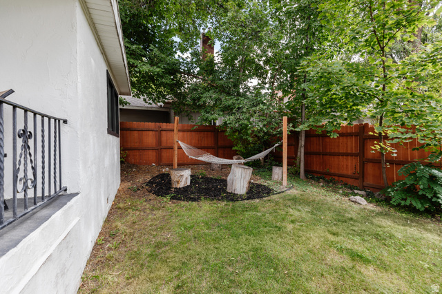 130 North 100 East Logan, UT 84321 - Photo 29 of 35 Expansive backyard featuring a privacy fence, mature trees, and a stucco exterior