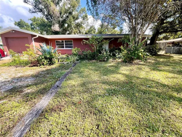 a view of a house with potted plants and large trees