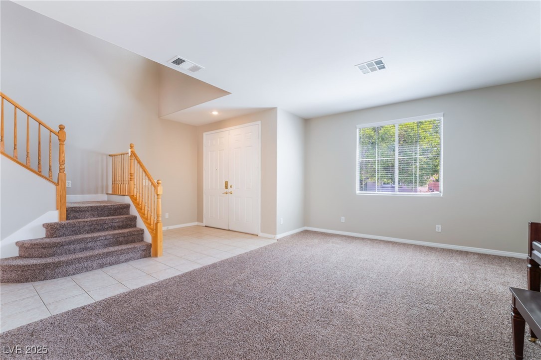 7857 Midnight Ride Street Las Vegas, NV 89131 - Photo 8 of 53 Foyer entrance featuring stairs, carpet floors, tile patterned flooring, and baseboards