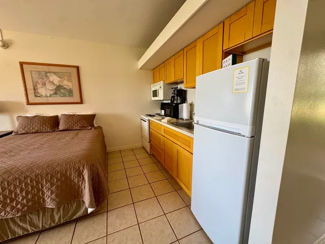 a bedroom with a bed and a refrigerator
