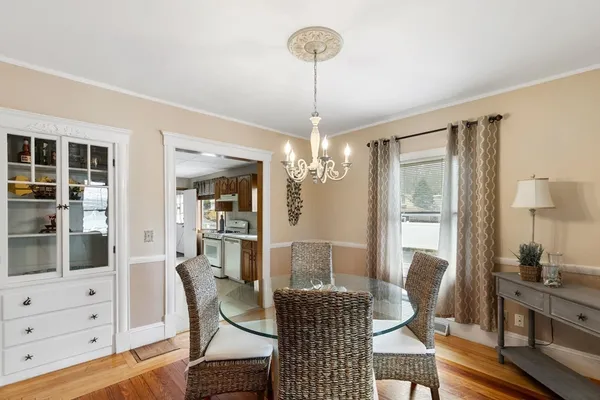 a dining room with furniture a chandelier and wooden floor