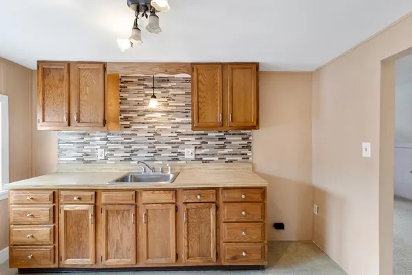 a kitchen with granite countertop a sink cabinets and a wooden floor