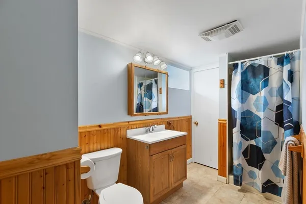 a bathroom with a toilet sink and mirror