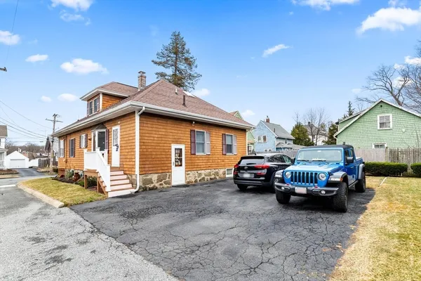 a front view of a house with cars parked