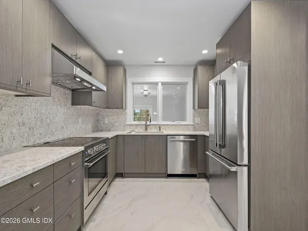a kitchen with stainless steel appliances granite countertop a refrigerator sink and stove