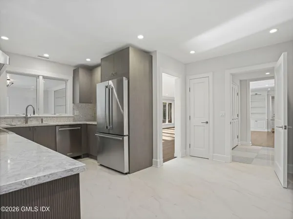 a kitchen with stainless steel appliances granite countertop a refrigerator and a sink
