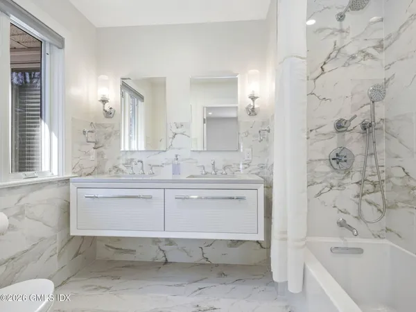 a bathroom with a granite countertop sink a toilet and bathtub