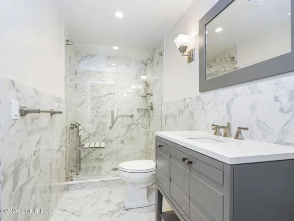 a bathroom with a sink a toilet and shower