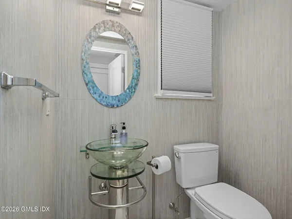 a bathroom with a toilet a sink and mirror