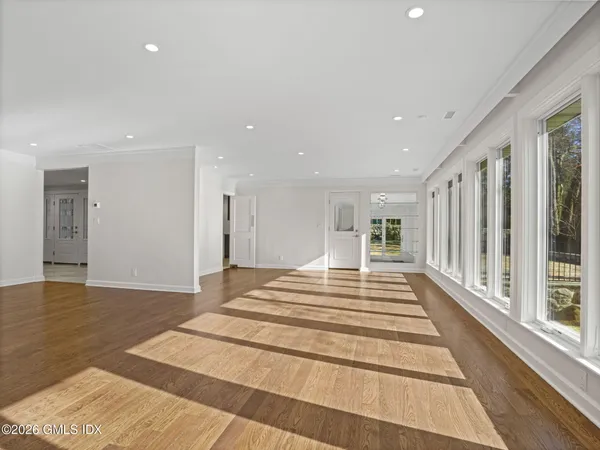 a view of a hallway with wooden floor and windows