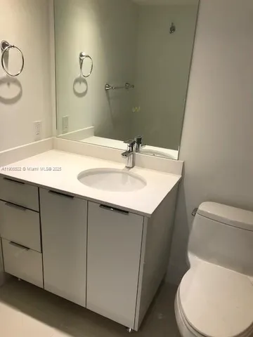 a bathroom with a sink mirror vanity and toilet