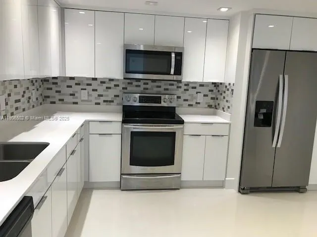 a kitchen with stainless steel appliances a stove a sink and a microwave