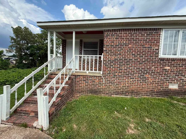 a view of a house with a wooden fence