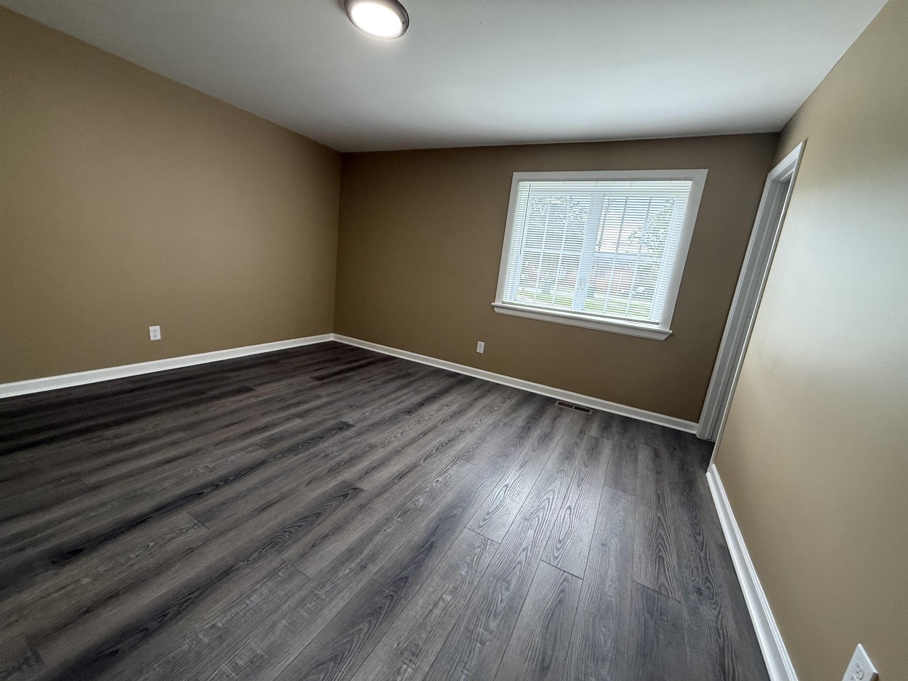 62 Cinnamon Drive, Unit LEFT Jackson, TN 38305 - Photo 5 of 8 an empty room with wooden floor and windows